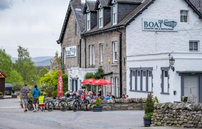 White hotel with colourful bushes and tables outside