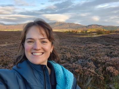 Person facing camera and smiling with a heather moorland in background