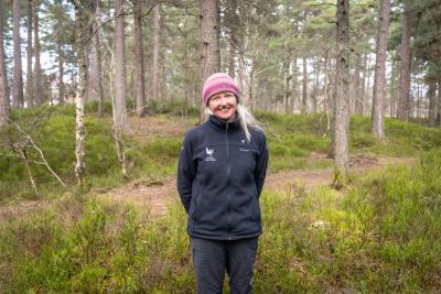 Countryside ranger with pink hat standing in forest