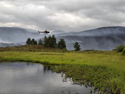 Helicopter above smoking trees