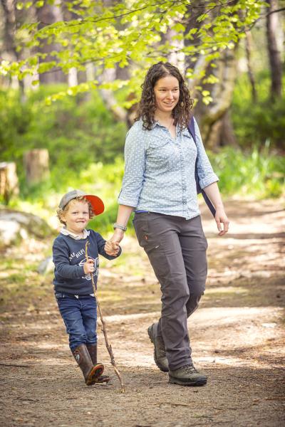 Woman and child walking on woodland path