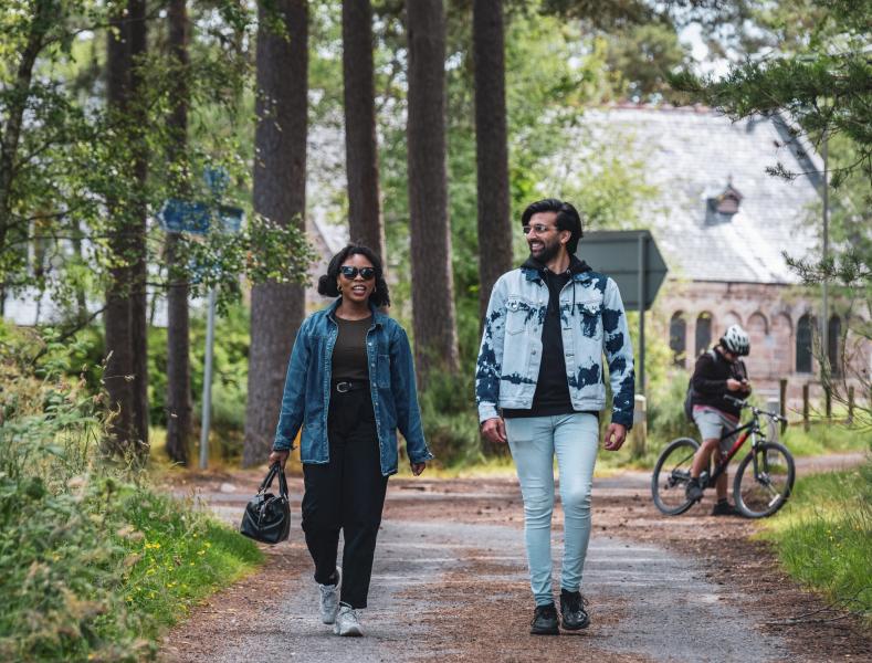 Two people walking in the forest.