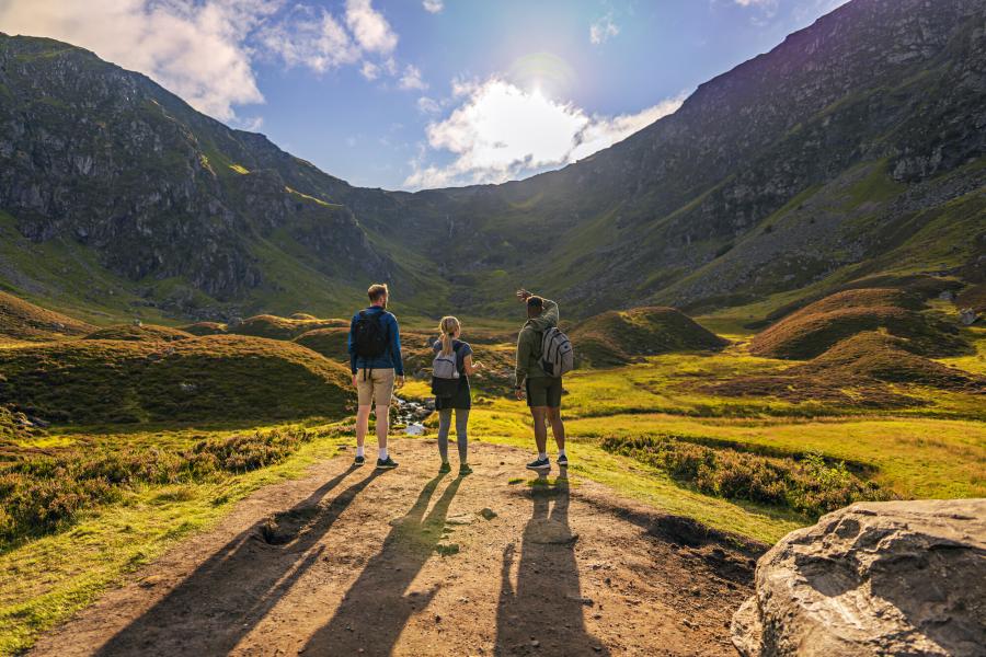 Three people standing in Corrie Fee admiring the view.