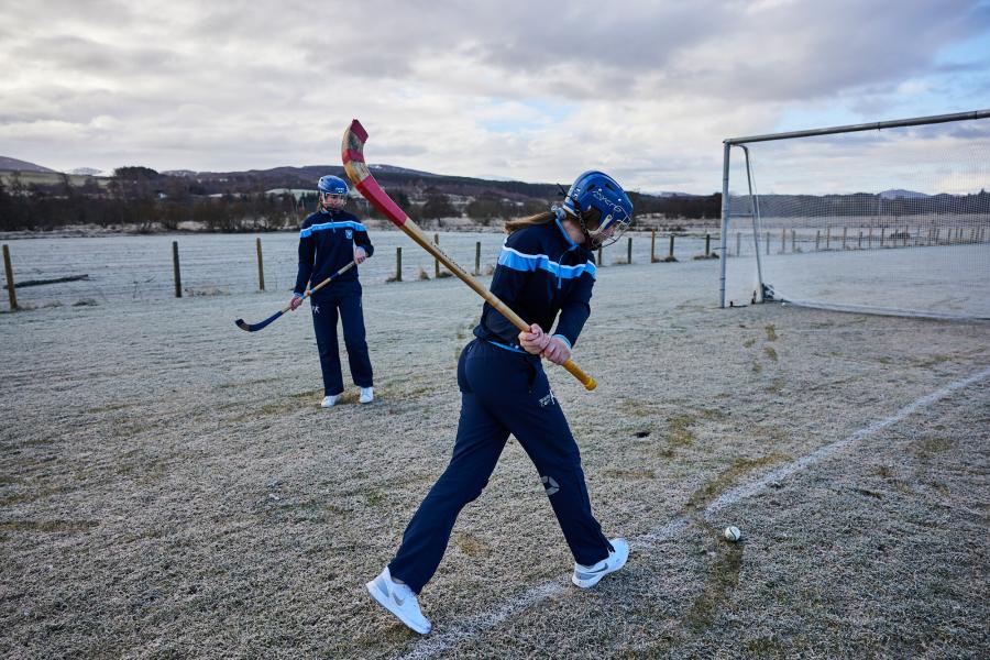 Two shinty players training on a frosty pitch at the Dell in Kingussie