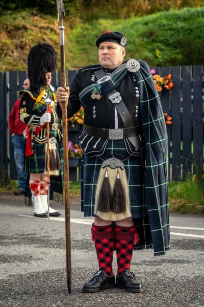 A Lonach Highlander in traditional dress with spear.