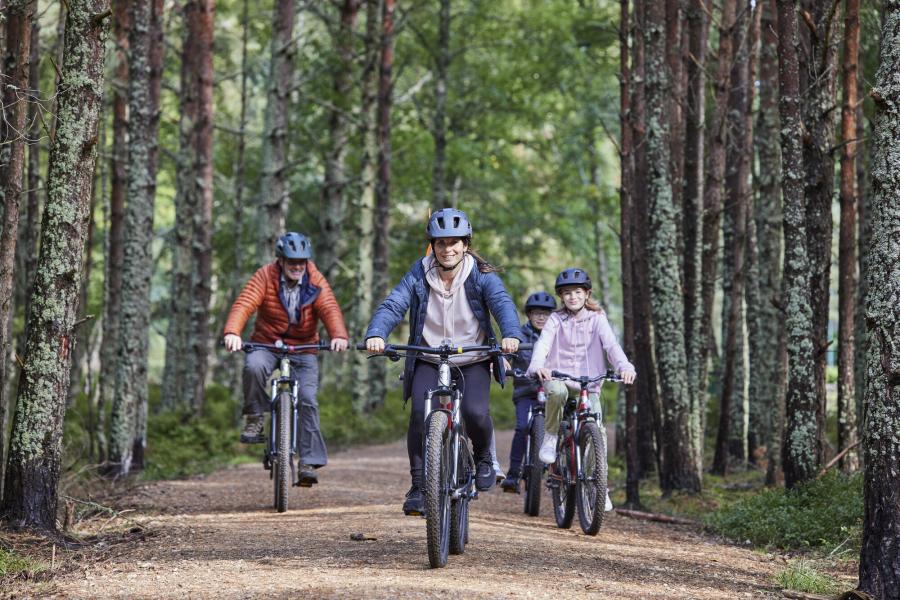 A family enjoy a cycle ride in the Cairngorms National Park.