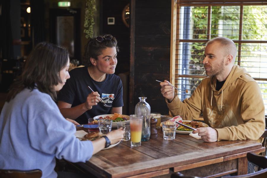 Three people enjoy a meal in a restaurant in the Cairngorms National Park.