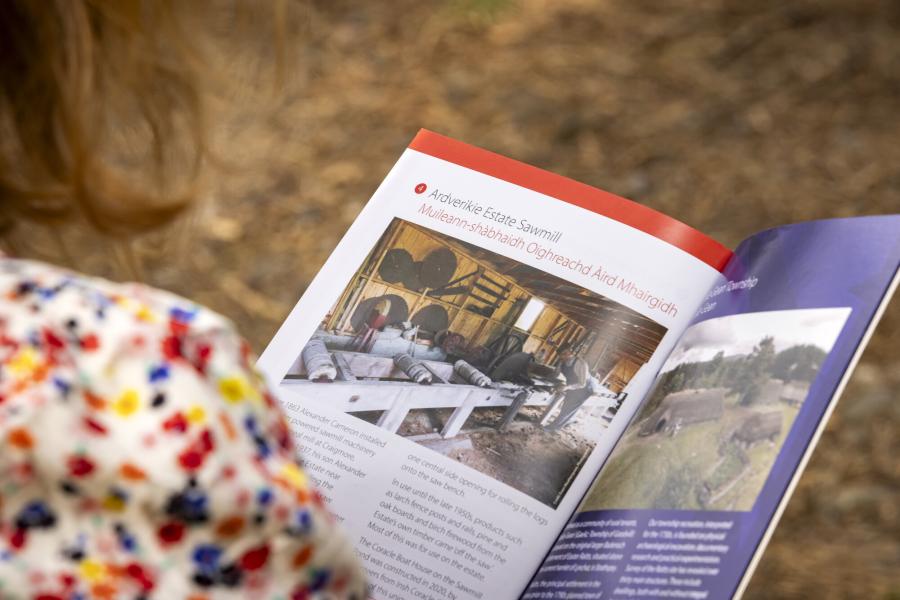 Person reading Highland Folk Museum leaflet on Ardverikie Estate Sawmill.