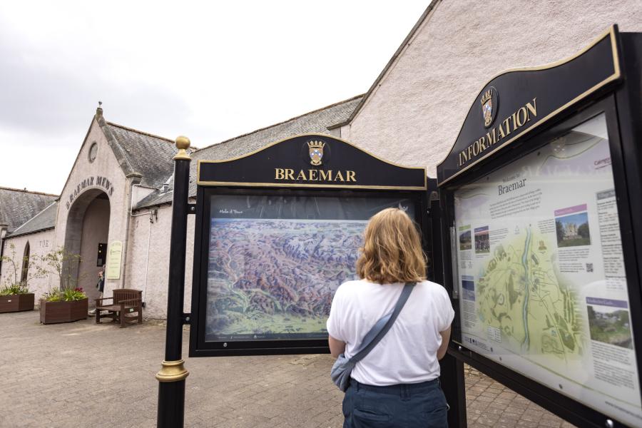 A person looking at a map on the Braemar public information board