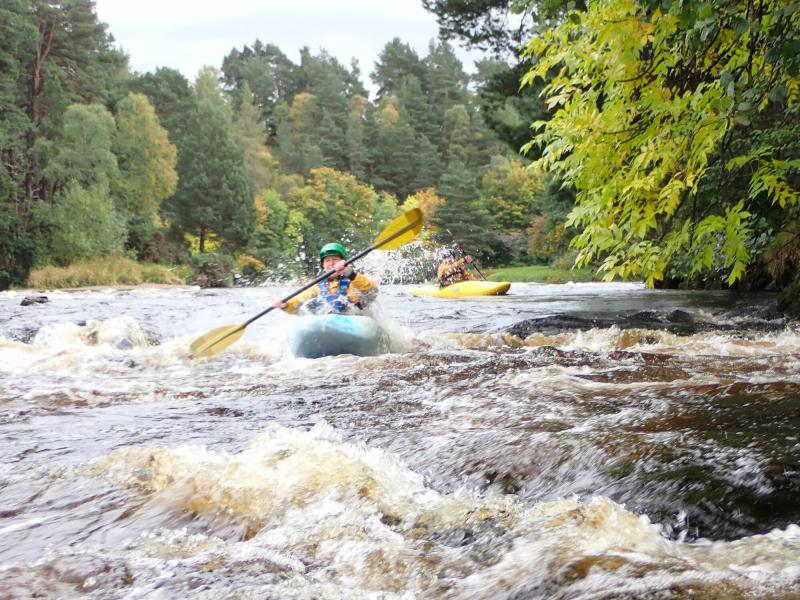 Two kayakers paddling on rough water on the river Spey