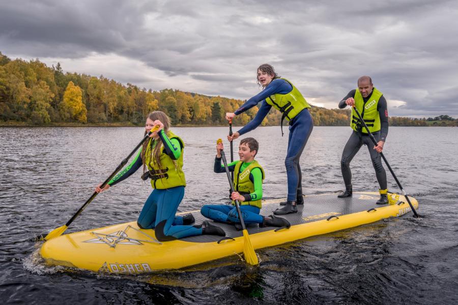 A family on a paddleboard on water