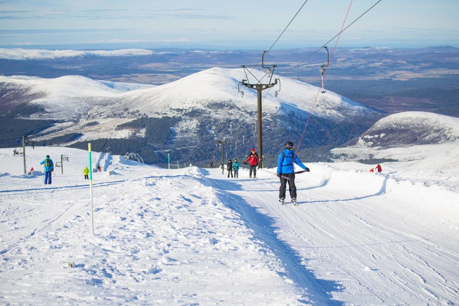 Skiers being pulled up the mountain by a ski tow on Cairngorm Mountain