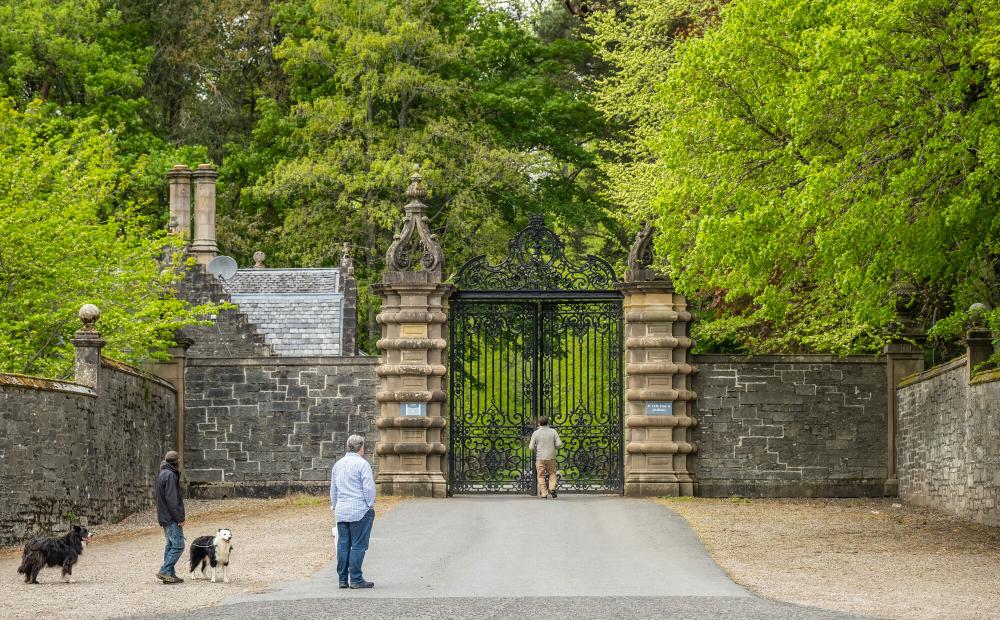 3 people and 2 dogs at the gates to Blair Atholl castle