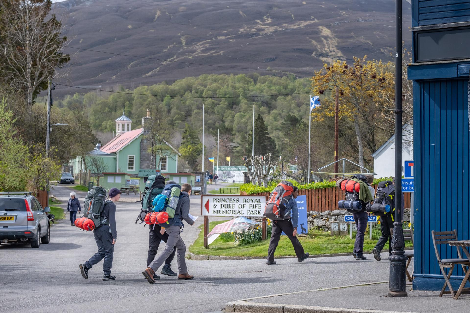 Group of walkers with rucksacks and sleeping mats in Braemar.