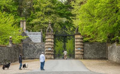 3 people and 2 dogs at the gates to Blair Atholl castle