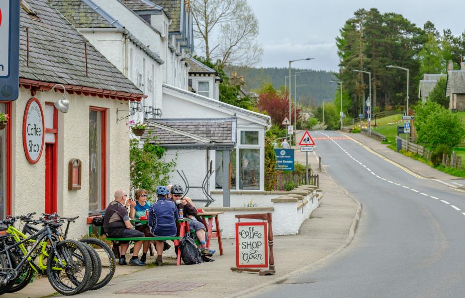 Cyclists sitting outside café in Carrbridge.