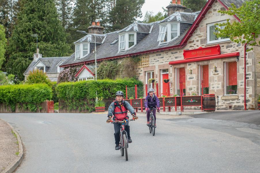 Two cyclists on street in Kincraig.