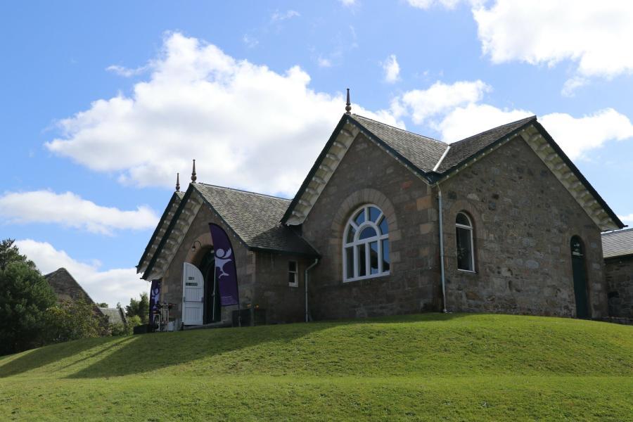 Carrbridge village hall with Cairngorms National Park flags outside for a Cairngorms 2030 drop in event.