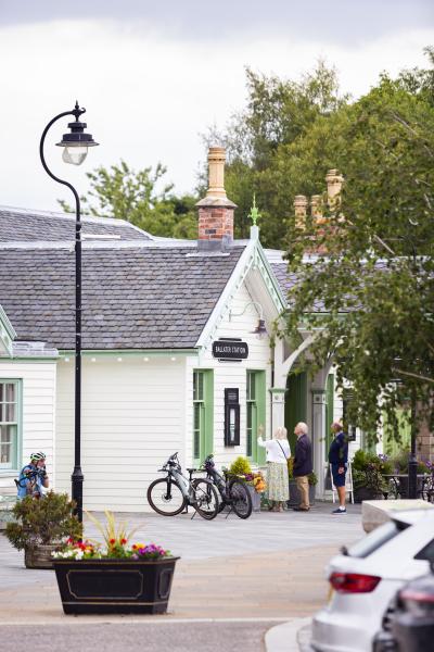 Bikes outside the former Ballater Railway Station with people looking at information board.