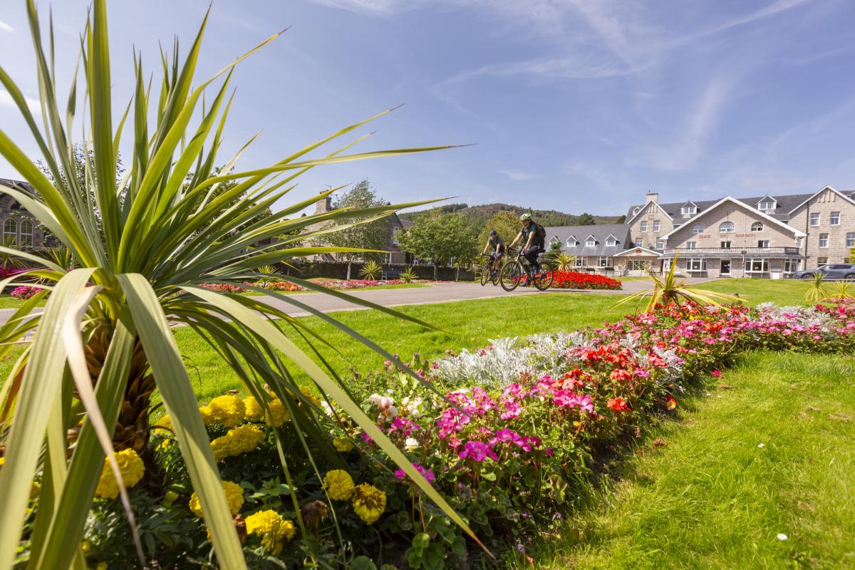 Two people riding bikes through the Gynack Gardens, Kingussie