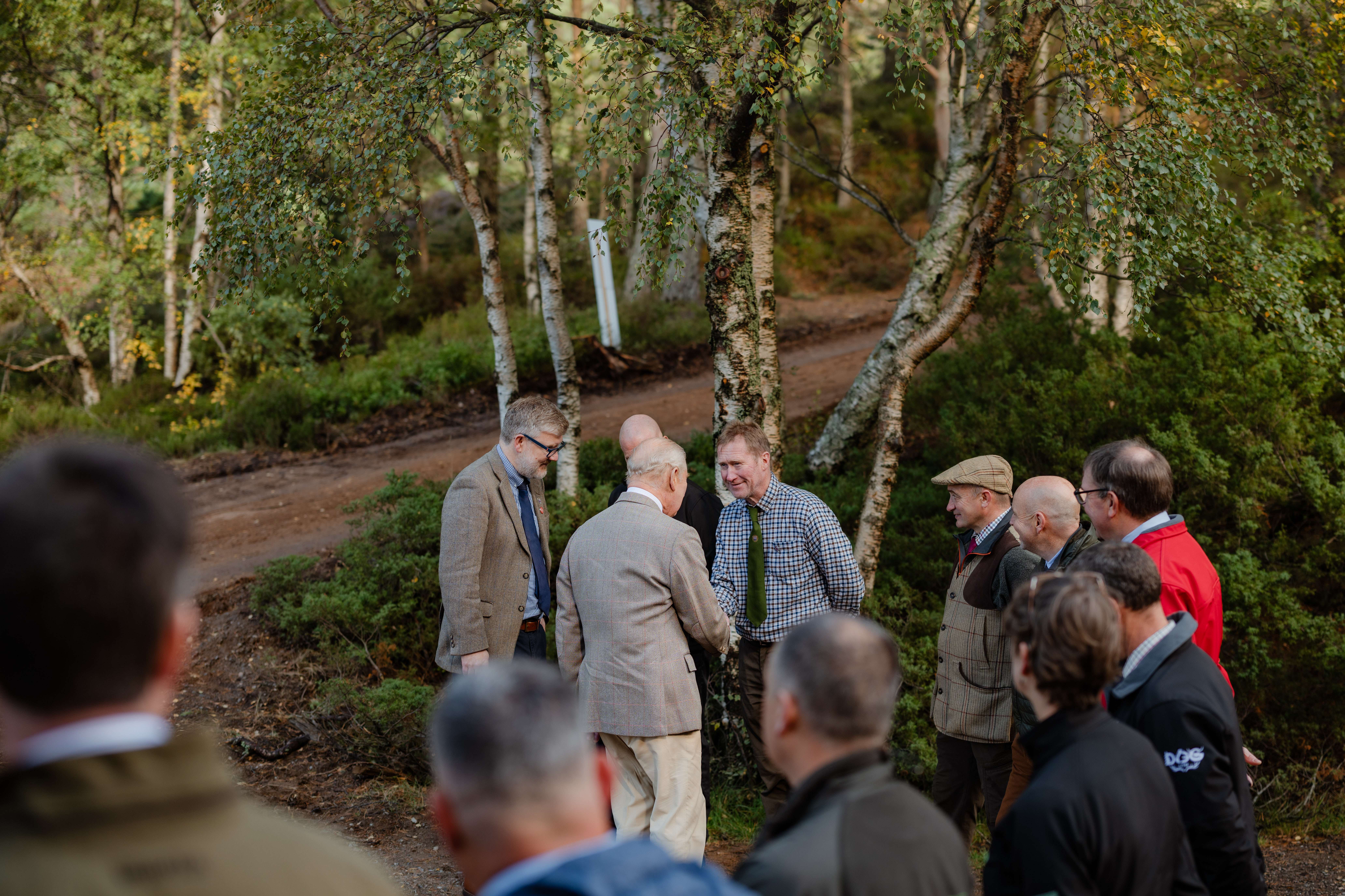 Group of people meeting with trees in the background