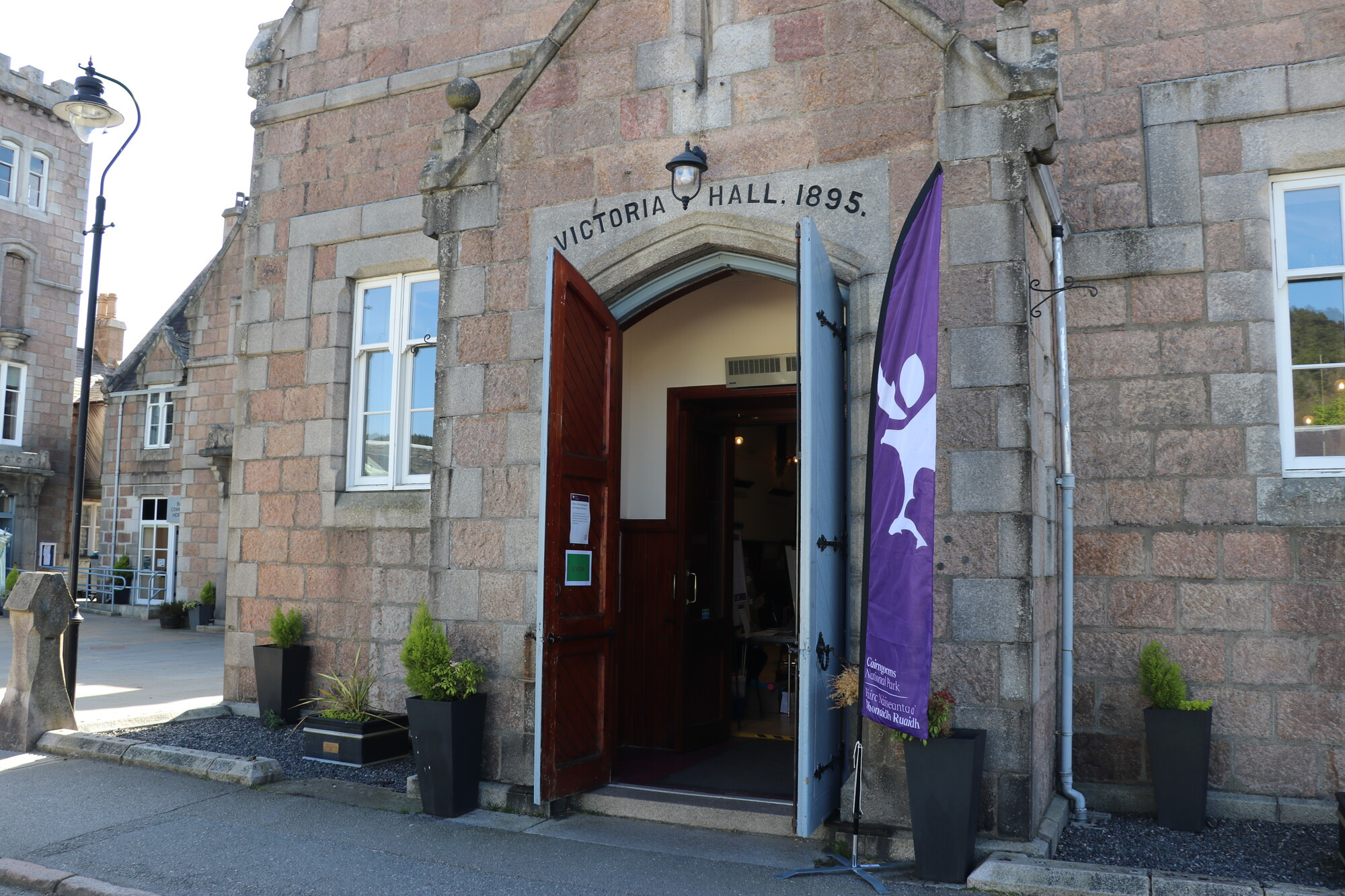Brick building with door open and purple flag on the right side