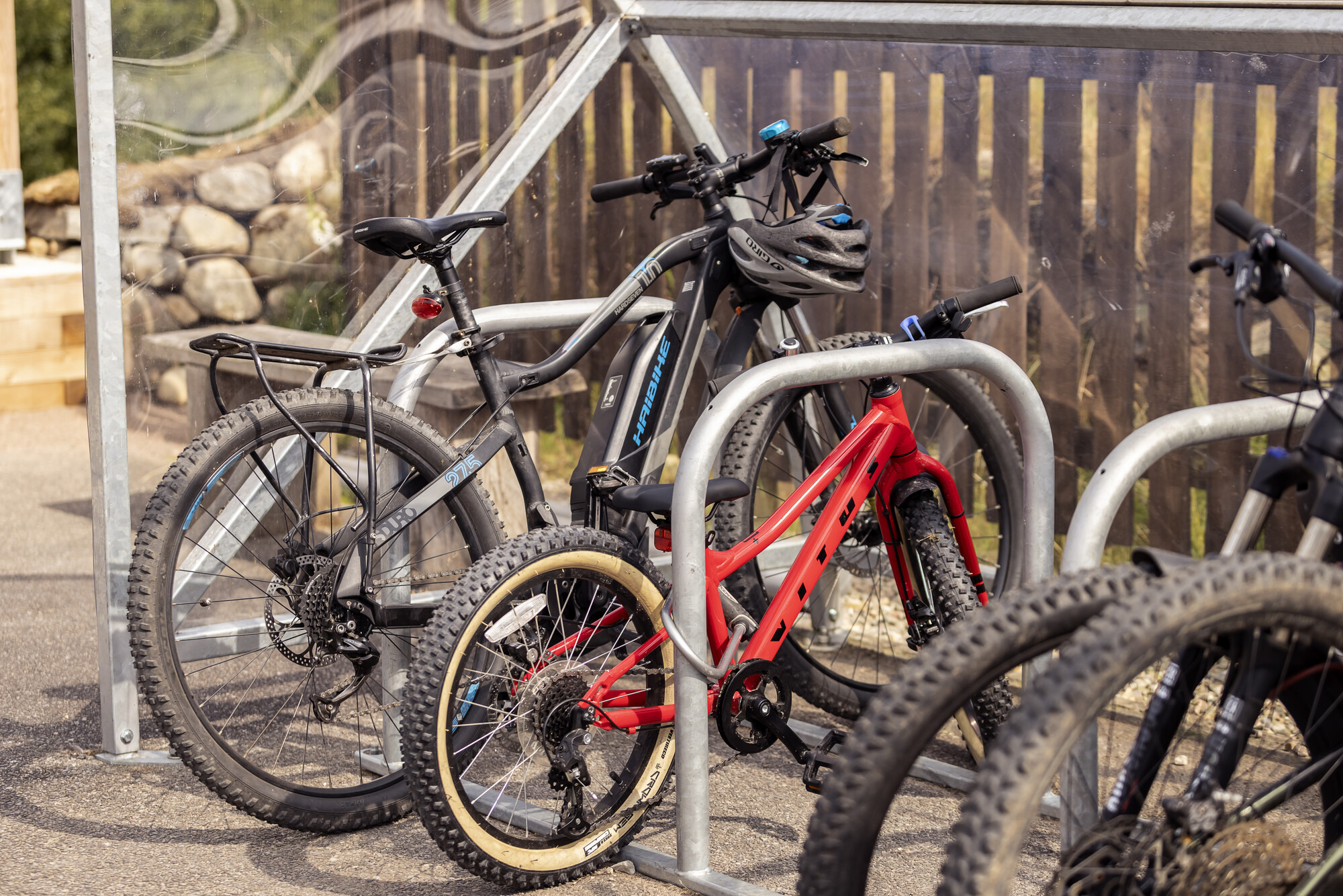 Bicycles attached to bike stands in a shelter.
