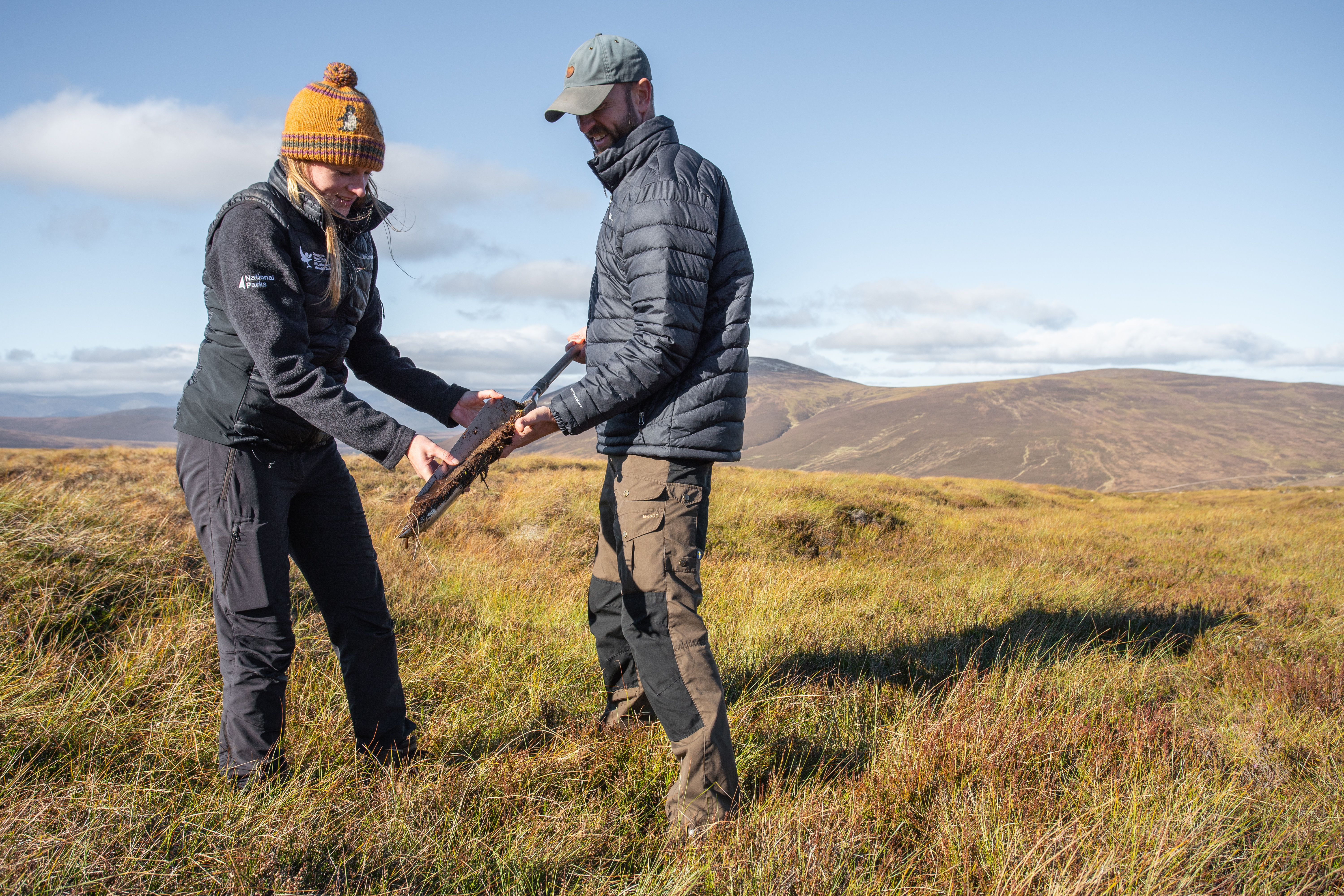 Members of the peatland team looking at a section of peat core taken from the bog