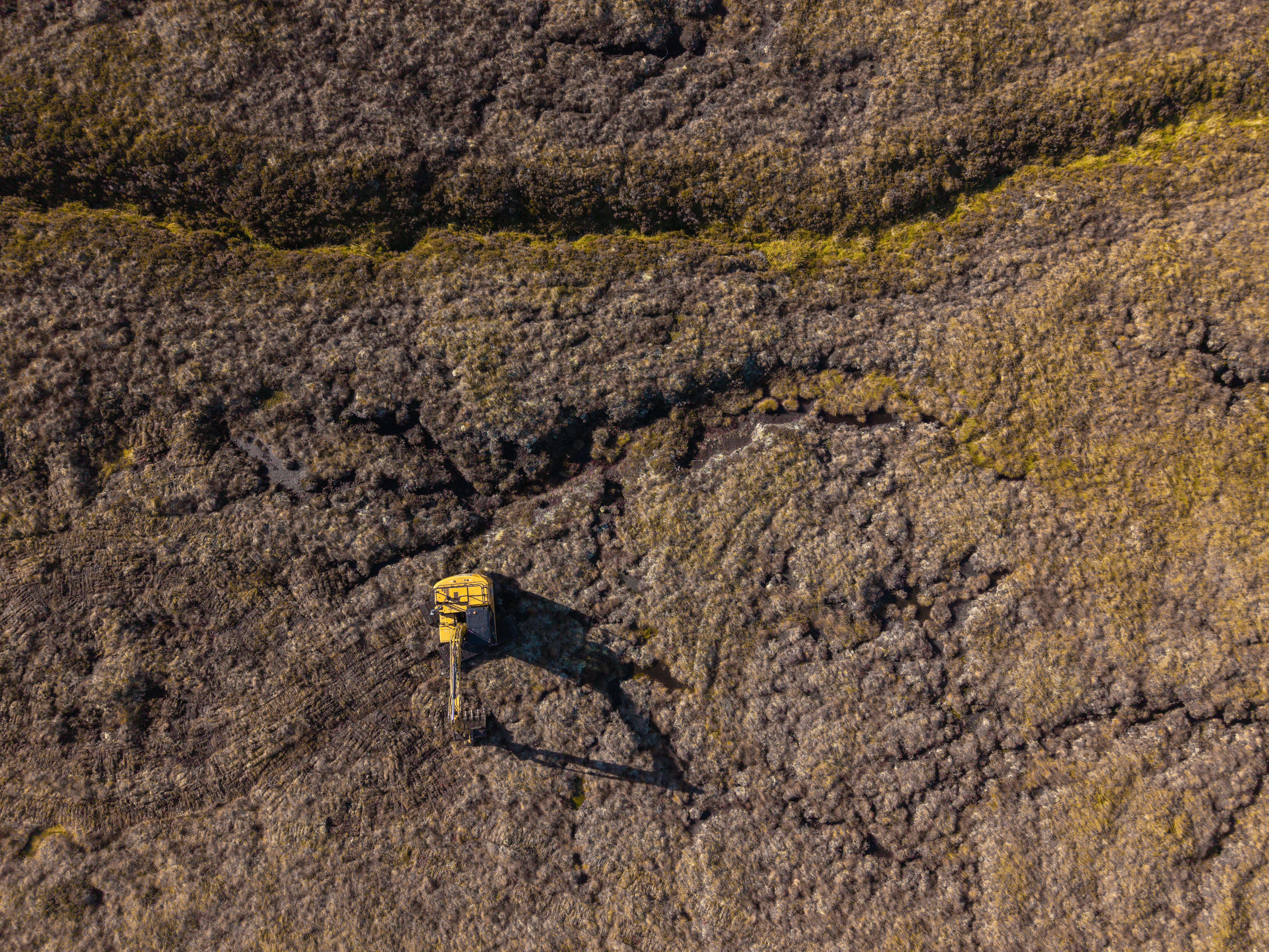 An aerial photo of a yellow digger in the middle of a peatland habitat