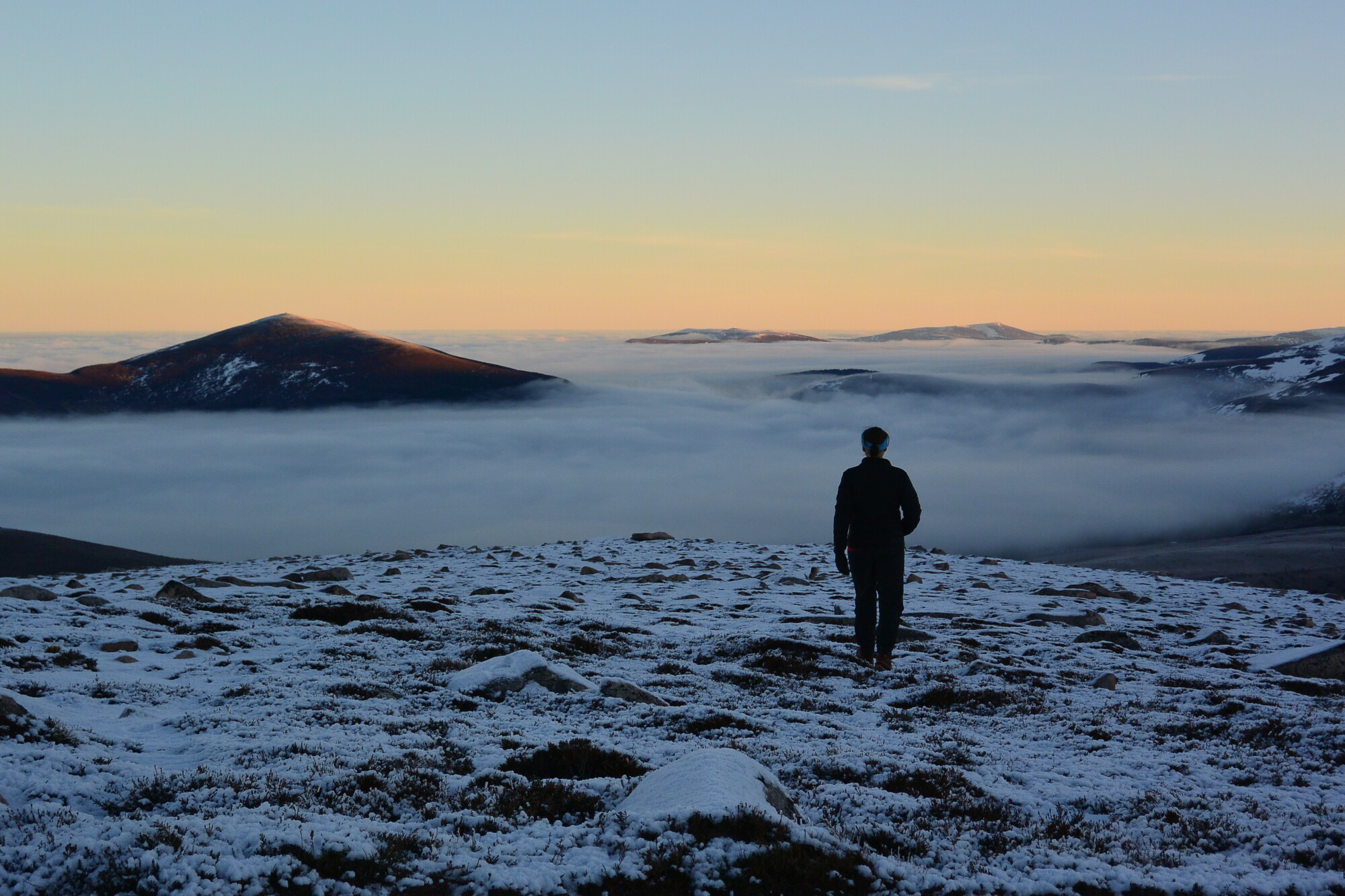 Temperature inversion at dawn, person looking over Meall a Bhuachaille and Morlich