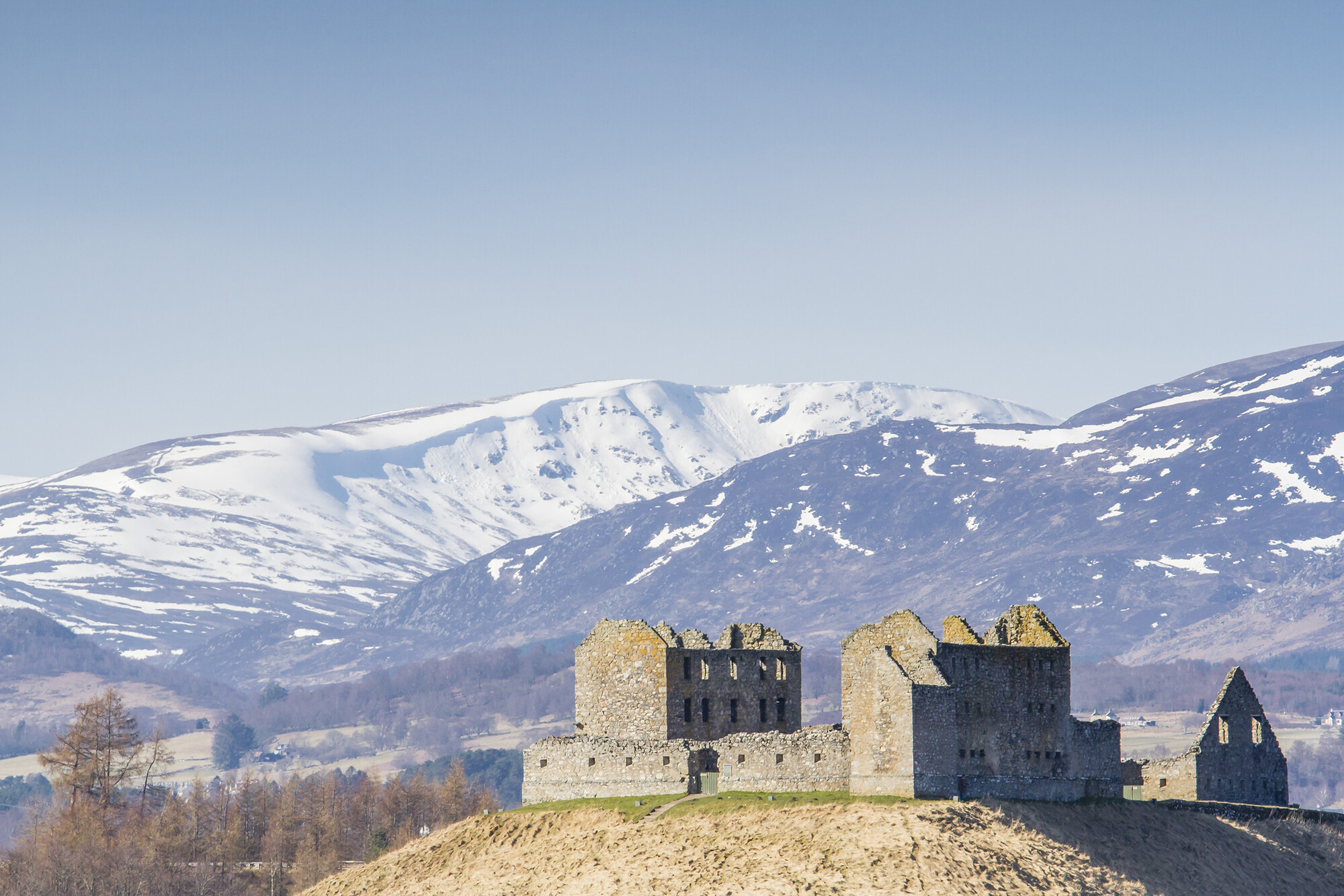 A view of Ruthven Barracks with snow covered mountains in the background