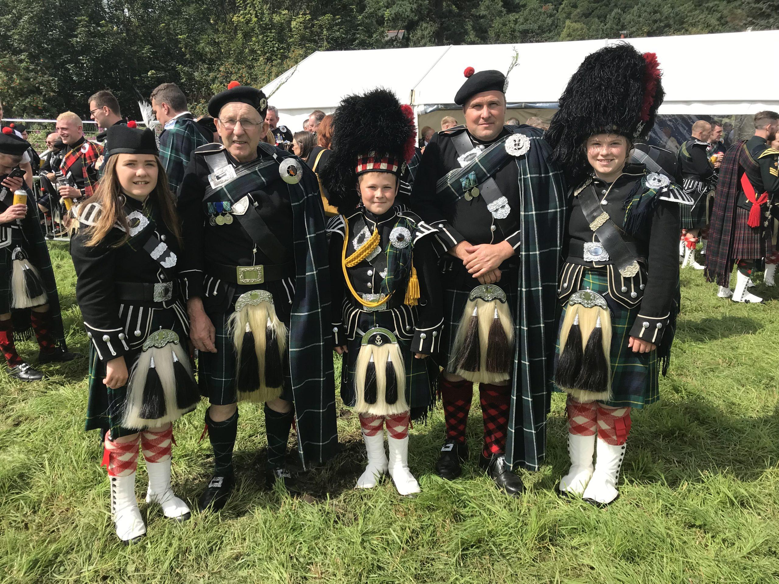 Image of Alanah, George, Cameron, Charles and Lucy Gordon wearing their Highland band attire.