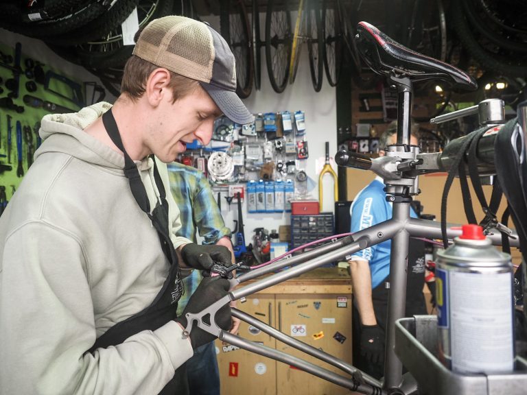 Person working on the brakes of a bike.