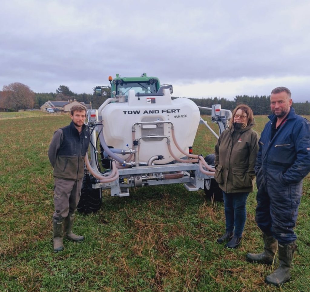 The Smith family, standing next to farm machinery on Culreach Farm by Nethy Bridge