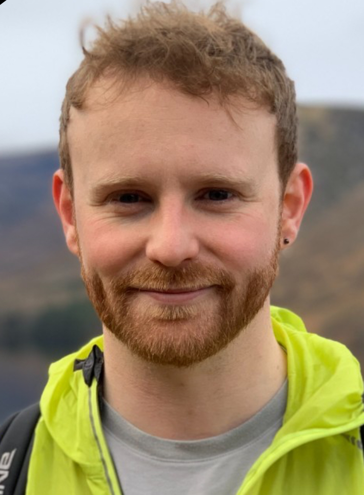Person with red hair and beard wearing a yellow jacket