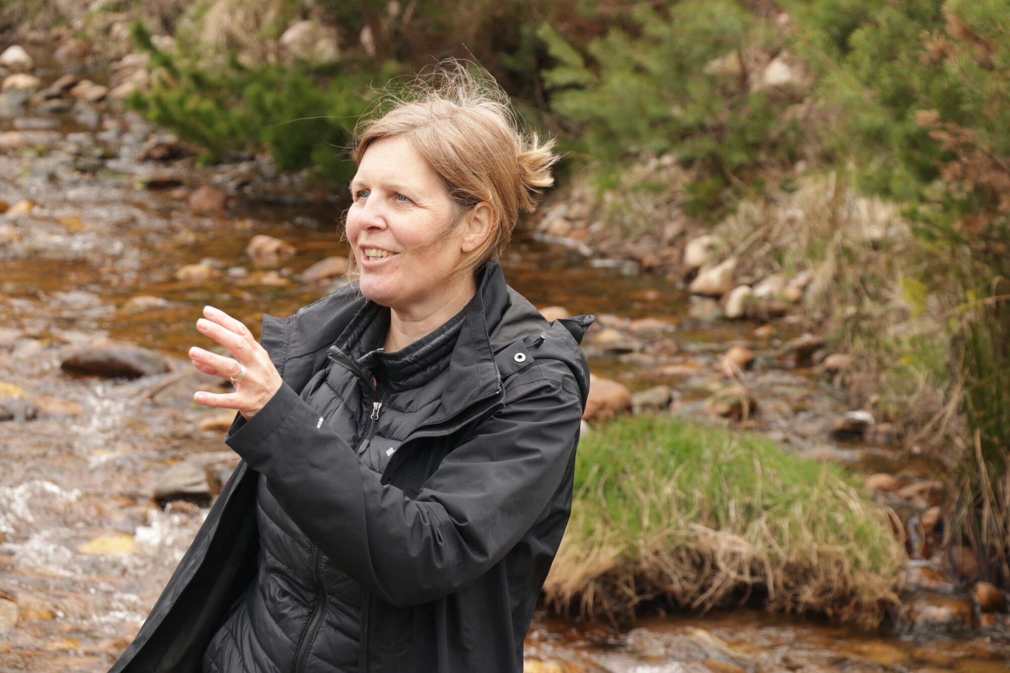 Person standing talking with river in background