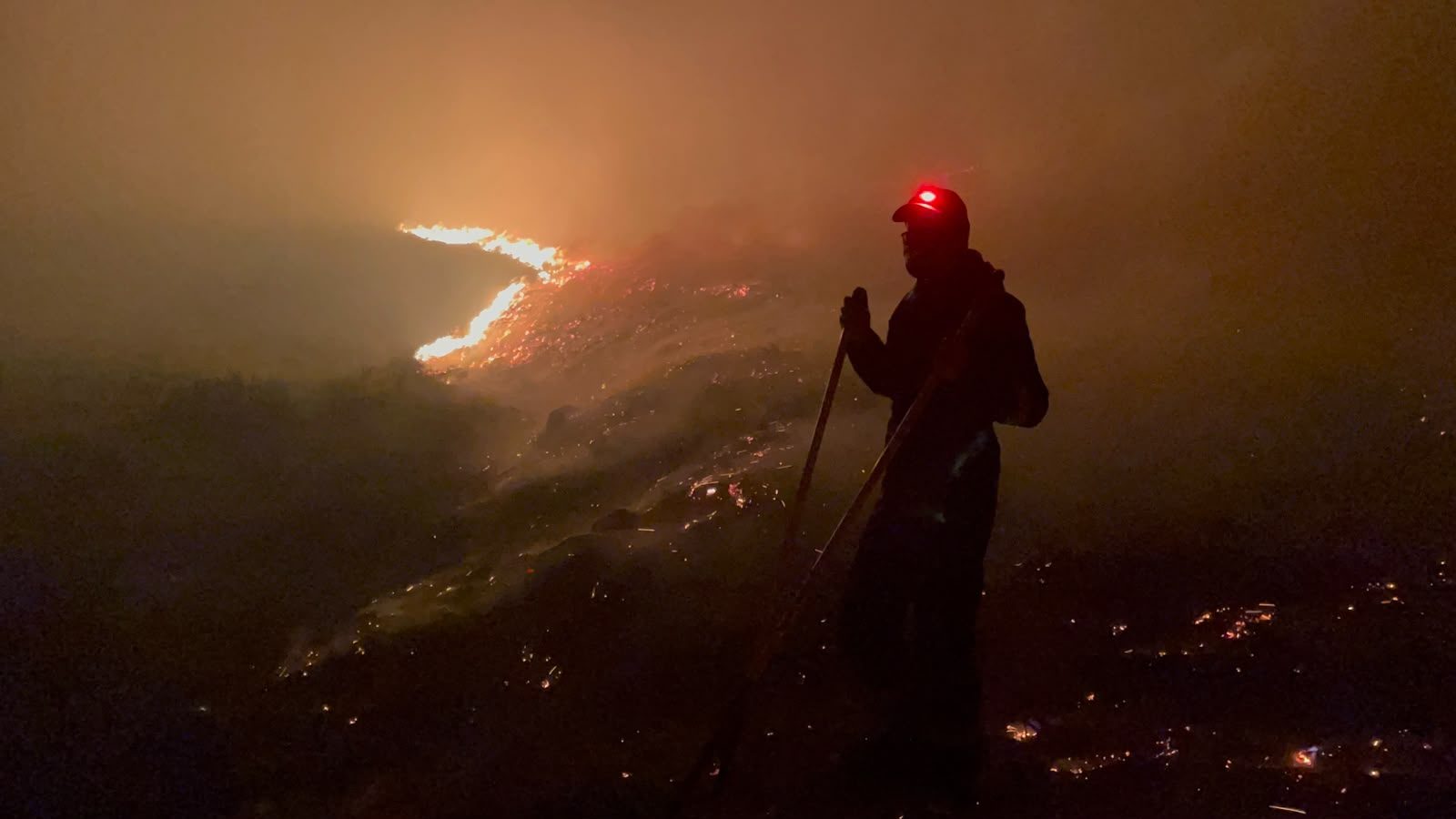 Person with PPE fighting the fire wearing a headtorch