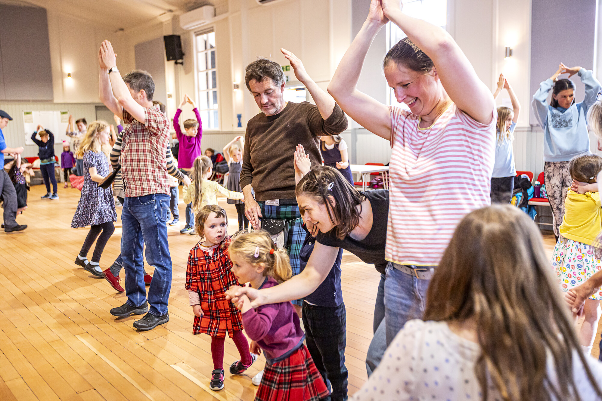 A family ceilidh dance in community hall.