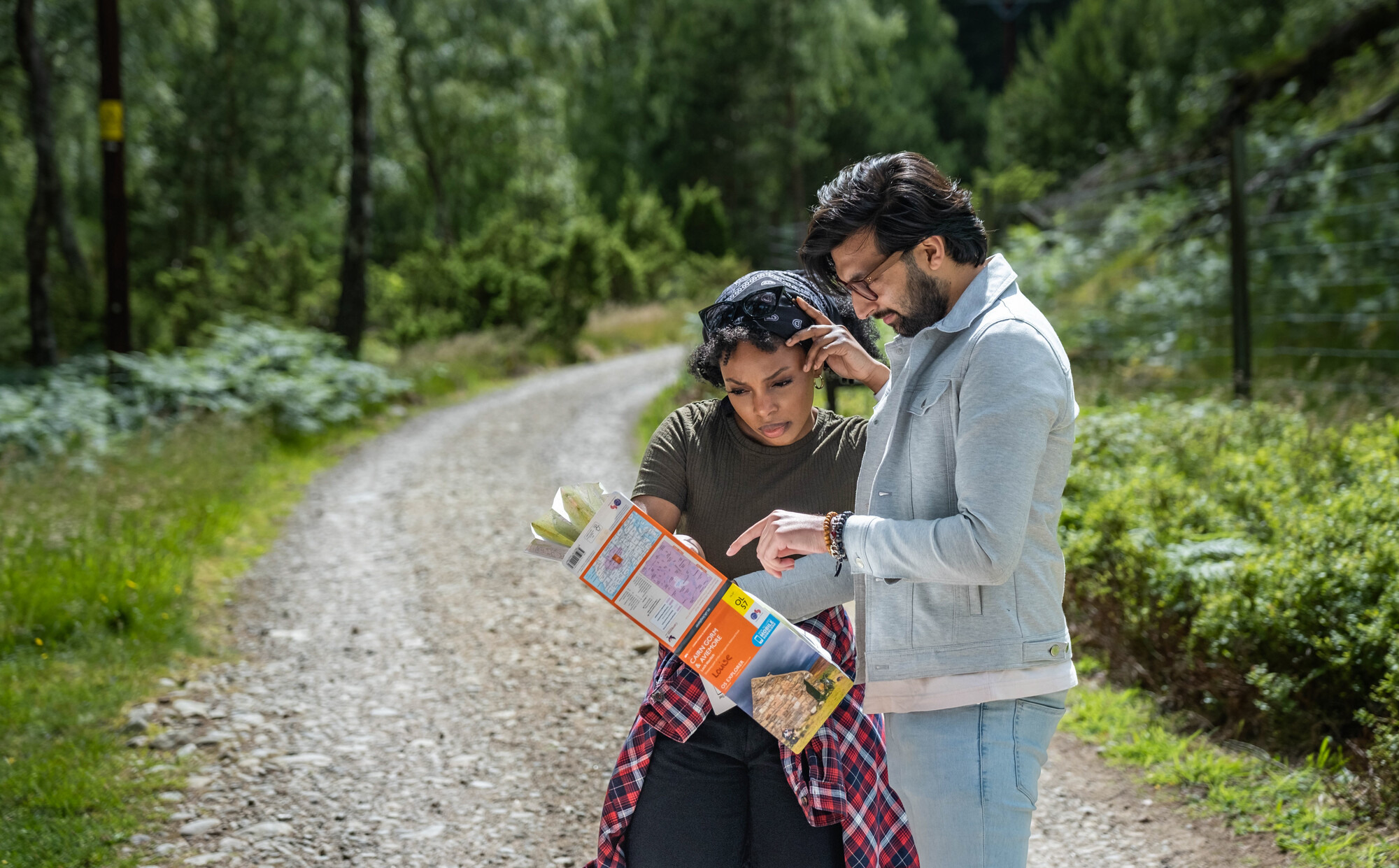 Couple looking at a map on a forest track in Rothiemurchus