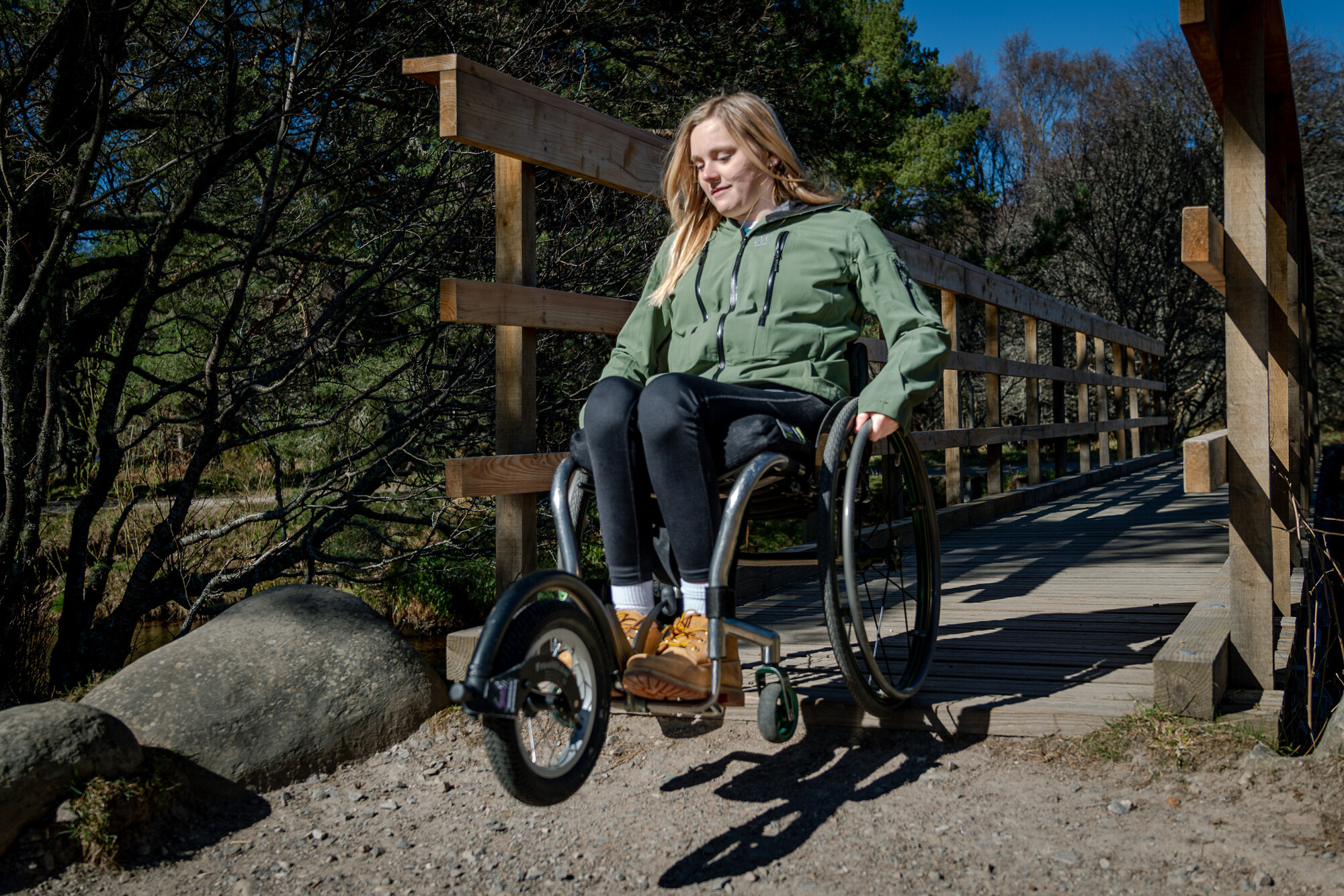 Person crossing a bridge on an all terrain wheelchair
