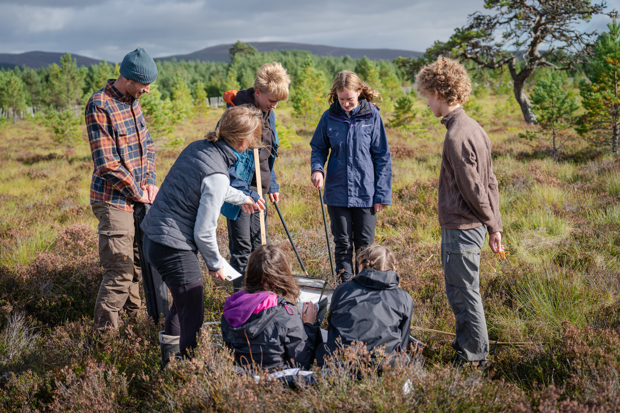 Park Authority Ranger Polly and Cairngorms Connect Community Learning Officer Lotte show pupils from Grantown Grammar how to monitor peatland.