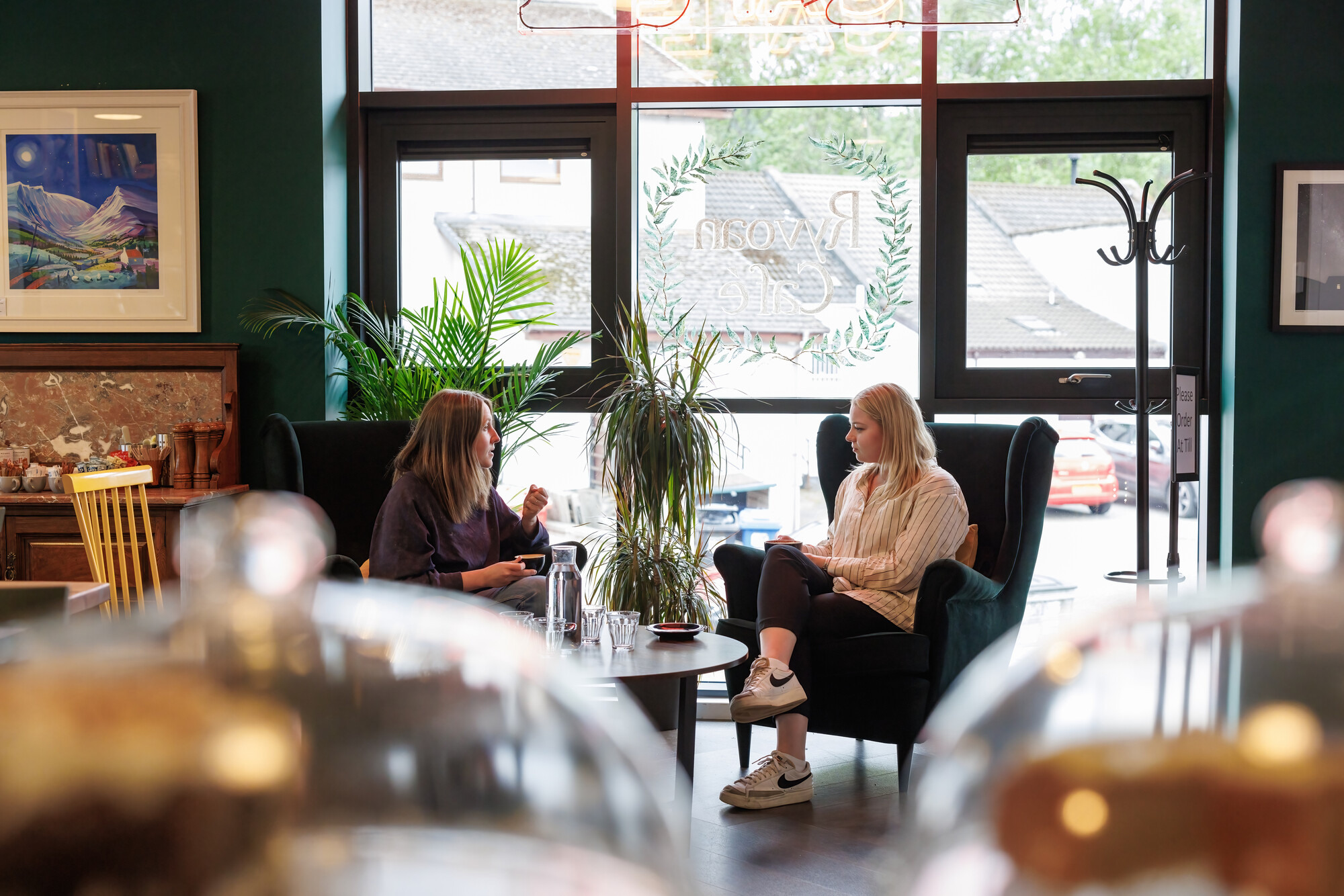 Two people enjoying a coffee and a catch up in a café in the Cairngorms National Park.
