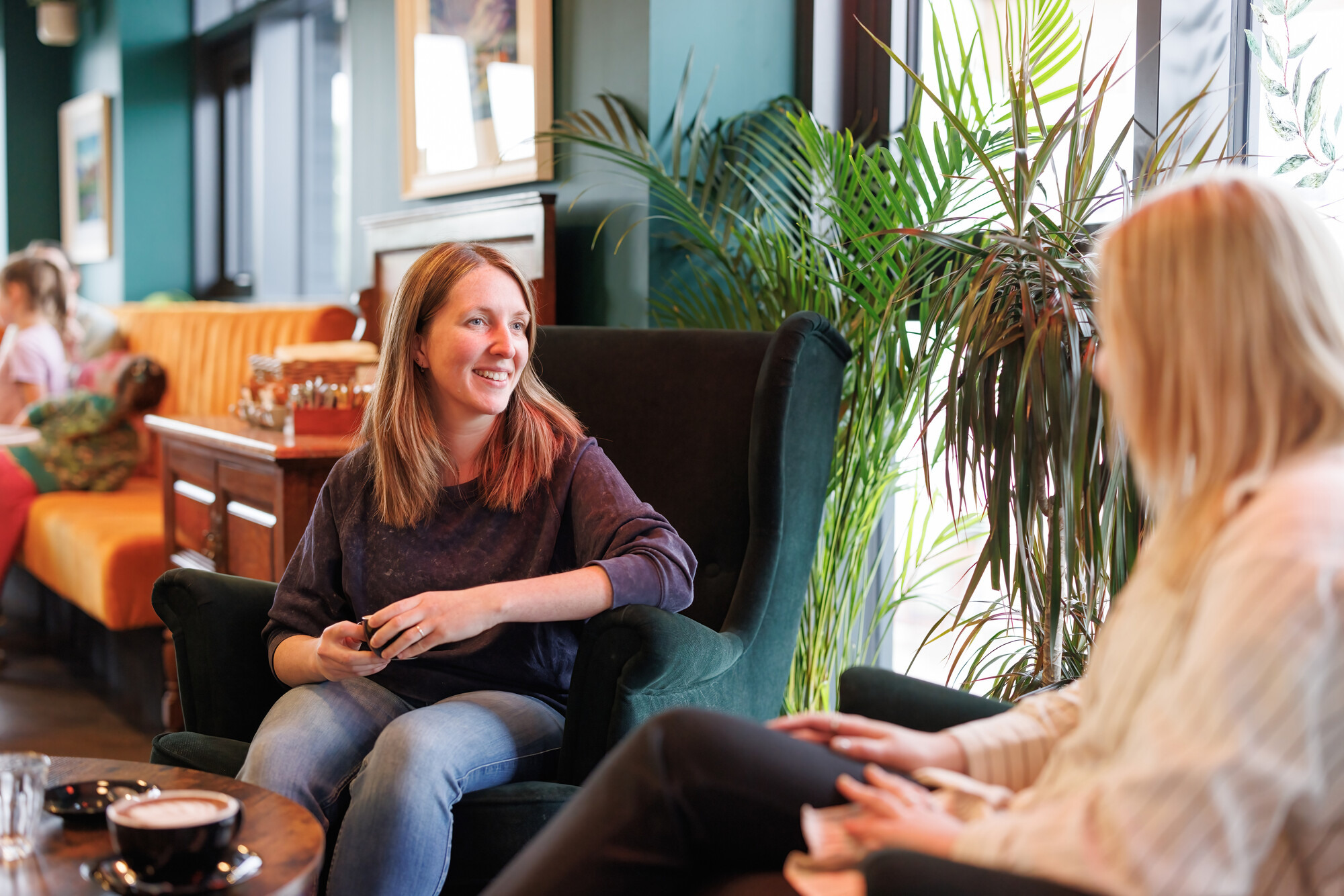 Two people enjoying a coffee and a catch up in a café.