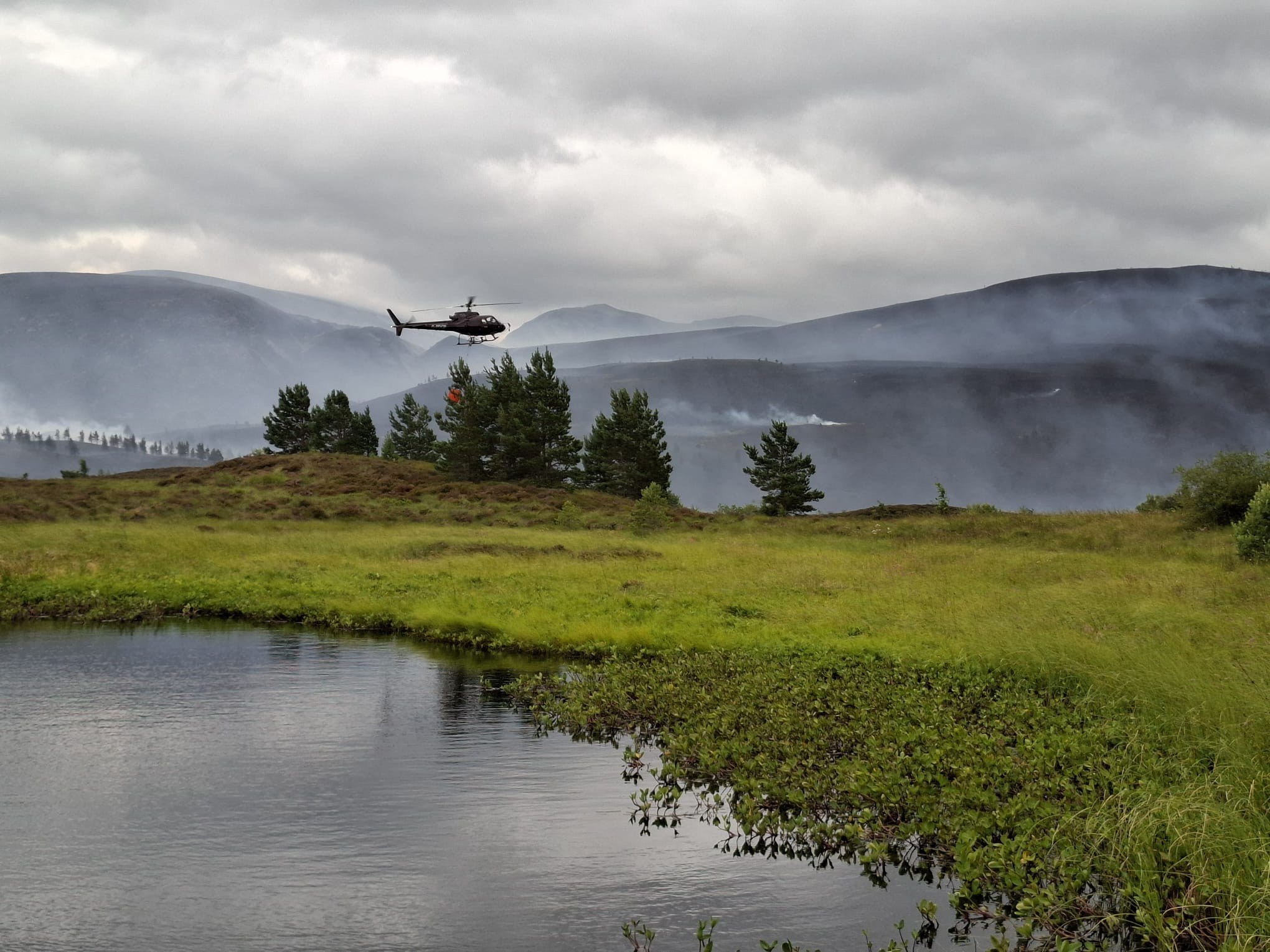 Helicopter above smoking trees