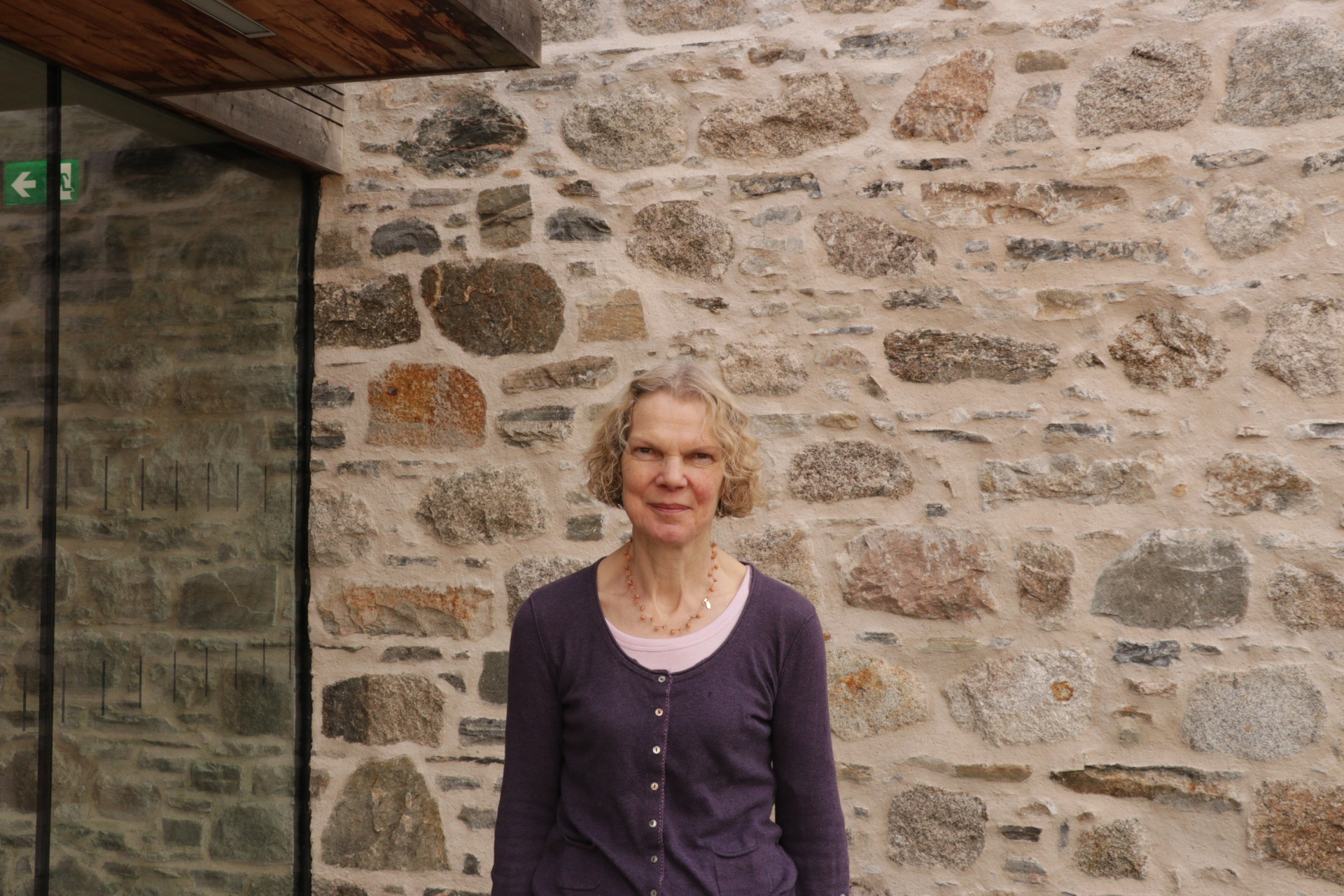 Fiona looks to camera outside the Park Authority offices against a stone wall