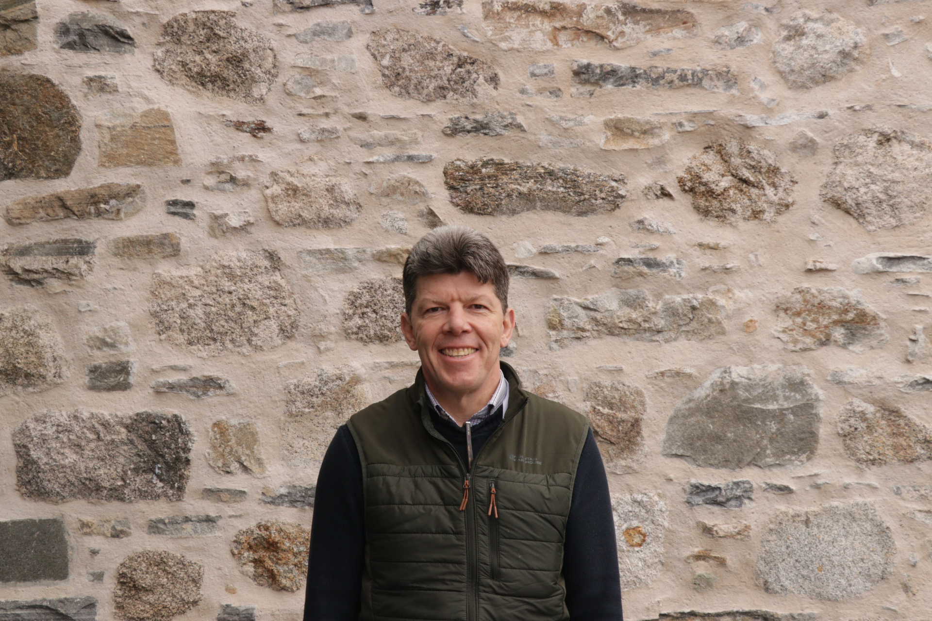 Paul Gibb headshot against stone wall