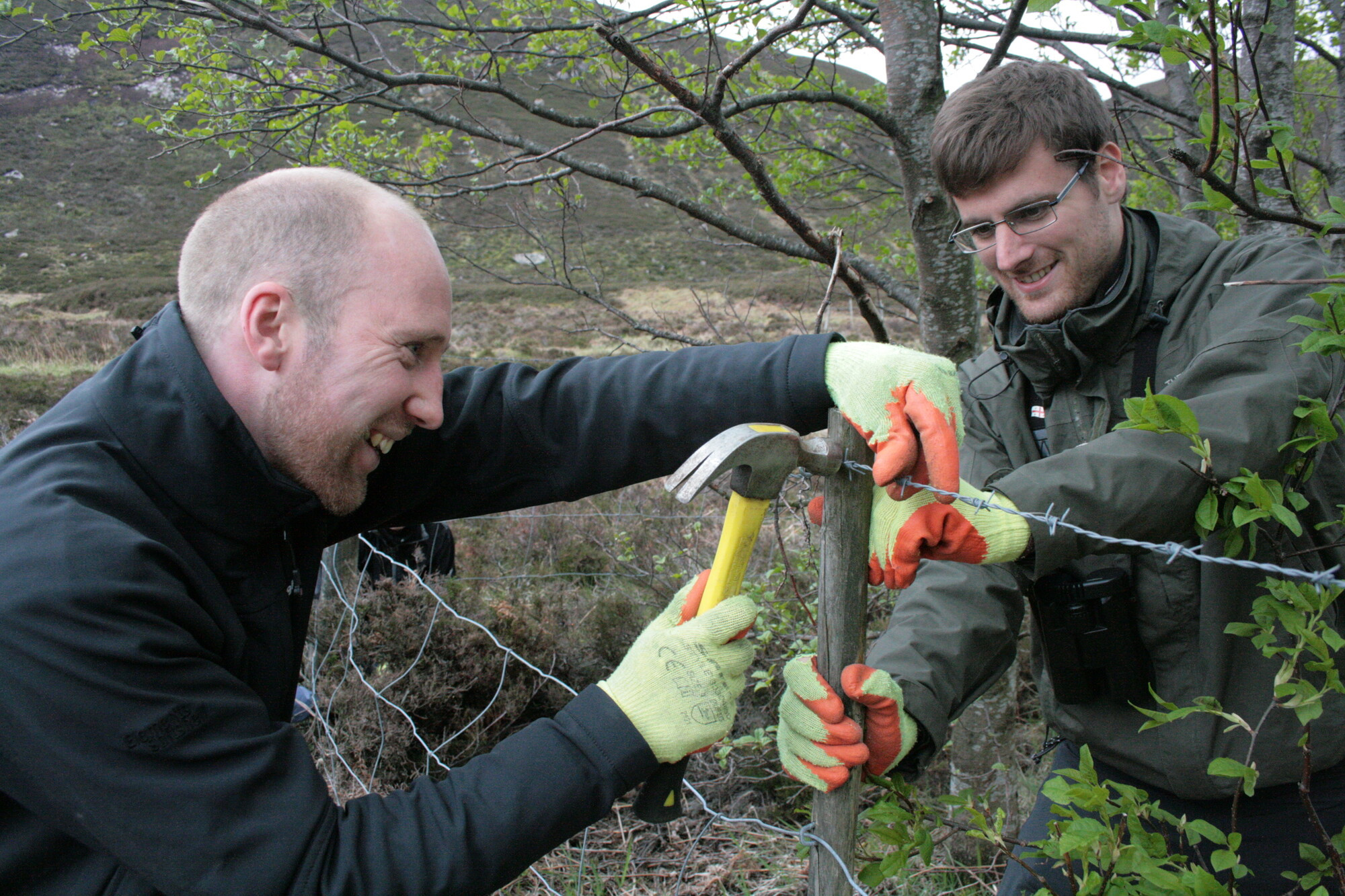 Two volunteers fixing a fence in Glen Tanar