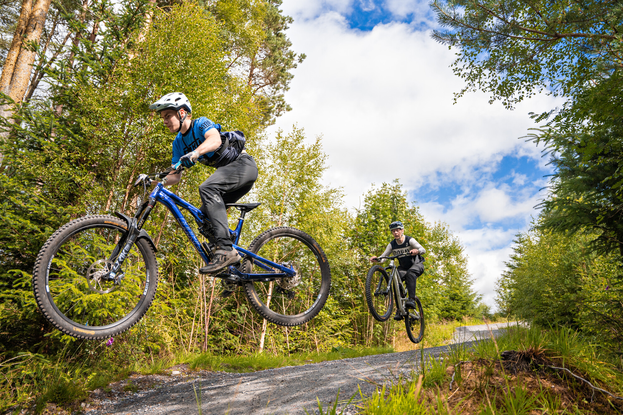 Two mountain bikers jumping at Laggan Wolftrax