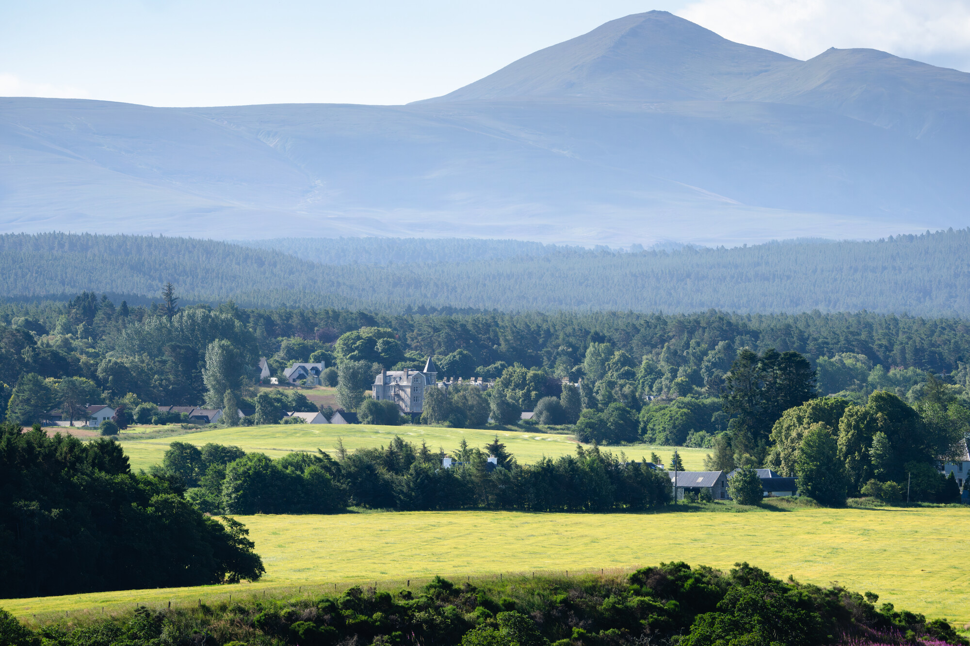 The forest town of Dulnain bridge with mountains in the background.
