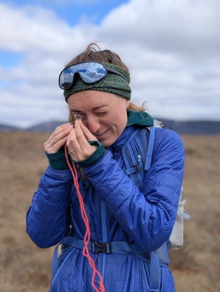 Peatland officer looking at a specimen through an eyeglass